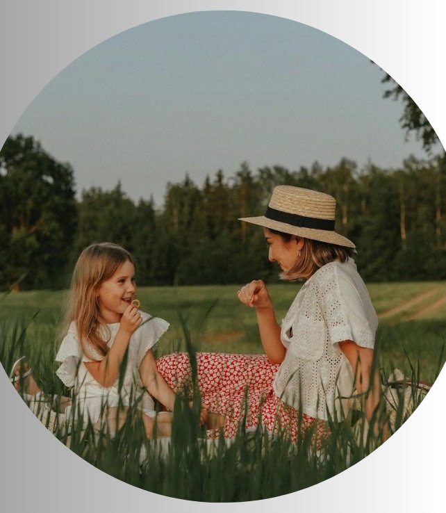 Mother and Daughter Sitting on a Grass Field while Having a Conversation